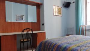 米兰2000酒店的一间卧室配有一张床、镜子和椅子