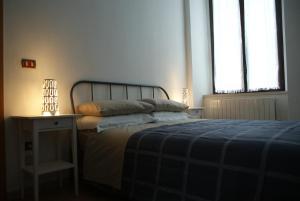 科森扎Casa Elisa的一间卧室配有一张带蓝色毯子的床和两个窗户。