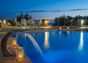 卡斯特罗西基亚Orizontas Residencies的夜间大型游泳池,拥有蓝色照明