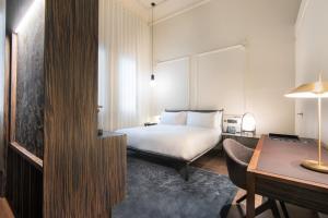 塞维利亚塞维利亚默瑟酒店的配有一张床和一张书桌的酒店客房
