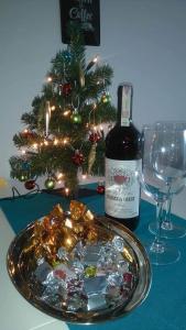 弗罗茨瓦夫Pod Mostem 2的一瓶葡萄酒和一盘糖果和一棵圣诞树