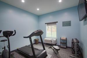 萨凡纳鸢尾花园酒店的一间健身房,内设健身器材,位于带蓝色墙壁的房间