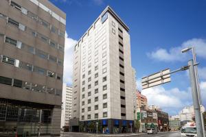 札幌MYSTAYS 札幌站北口酒店的一条城市街道上高大的白色建筑