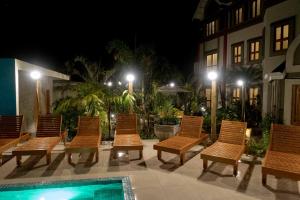 乌巴图巴Pousada Castello Montemare的一群椅子在晚上坐在泳池旁