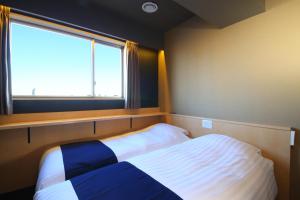 东京浅草驹形WING国际酒店 的一间小卧室,配有床和窗户