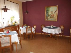 埃施韦格Hotel Garni am Heuberg的一间用餐室,配有2张带白色桌布的桌子