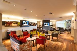 格拉斯哥格拉斯哥西区莱昂纳多酒店的一间设有桌椅和电视的等候室