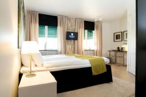 萨拉汀吉特酒店的一间卧室配有一张带灯和窗户的床