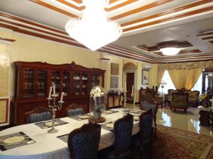 达沃市行政别墅套房旅馆的一间带桌子和吊灯的用餐室