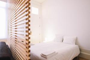 波尔图ORM - Ferreira Borges Apartment的卧室配有白色的床和窗户。