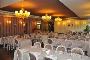布拉索夫Hotel Rainer的宴会厅配有白色的桌椅和吊灯