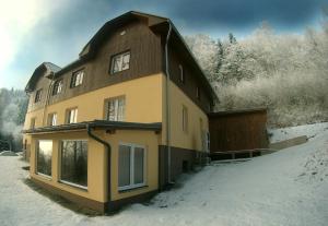 卢捷拿纳德德斯努Chata Eliška的雪中大房子,有雪覆盖的树木