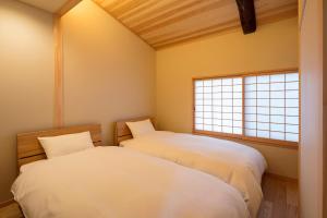 京都嵨原怀传町家的带2扇窗户的客房内的2张床