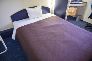 伊势崎市伊势崎精选酒店的一间卧室配有一张大床和紫色毯子