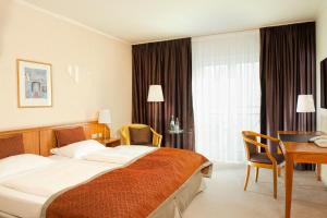 汉诺威温德姆汉诺威庭酒店的酒店客房设有一张大床和一张书桌。