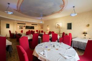 布雷叙尔拉布尔奥尔酒店的一间带桌子和红色椅子的用餐室以及天花板
