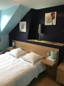 巴黎地匹酒店的卧室配有一张床,墙上挂有两张照片