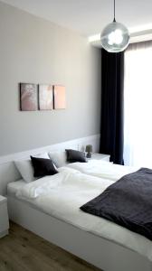 第比利斯Happy Apartment 7的白色卧室配有一张带黑色枕头的大型白色床