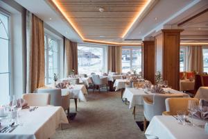 施图拜河谷新施蒂夫特Premium Activehotel Bergkönig的餐厅设有白色的桌椅和窗户。