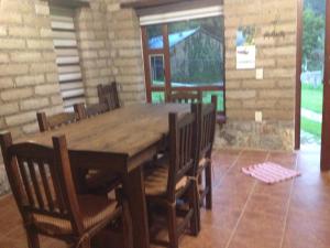 小米内拉尔Cabañas Hojarasca的一间带木桌和椅子的用餐室