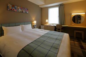 神户神户蒙特埃马纳酒店・艾美丽的一间卧室配有一张床、一张书桌和一个窗户。