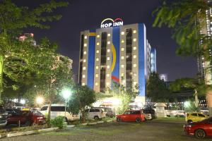 马尼拉Hop Inn Hotel Ermita Manila的一座带停车场的汽车的旅馆大楼