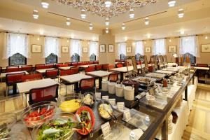 神户神户蒙特埃马纳酒店・艾美丽的大房间设有桌椅,并备有食物
