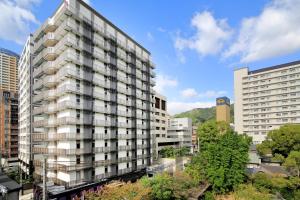 神户神户蒙特埃马纳酒店・艾美丽的一座高大的公寓楼,位于城市中,拥有建筑