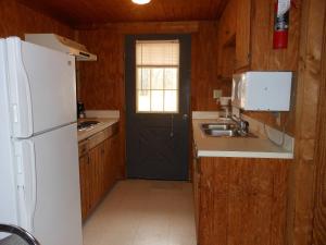 布里奇波特Bay Landing Camping Resort Deluxe Cabin 29的厨房配有白色冰箱和水槽