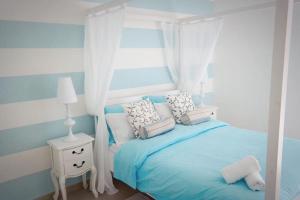 克伦蒂Kantra Residence的一间卧室配有蓝色的床、枕头和窗户