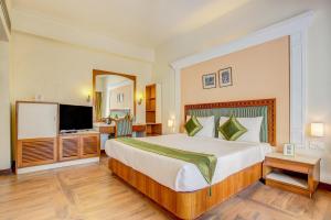 德拉敦Hotel Ajanta Continental的酒店客房设有一张大床和一台电视。