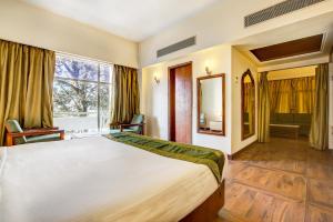 德拉敦Hotel Ajanta Continental的一间卧室设有一张大床和一个大窗户