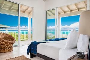 南凯科斯Sailrock South Caicos - Island Hop Flight Included的一间卧室配有一张床,享有海景