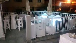 坎德拉里奥Hostal Restaurante Pasaje的阳台上的一组白色椅子和桌子
