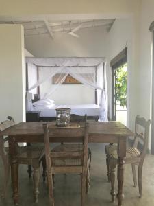 乌纳瓦图纳劳拉之家酒店的一张木桌、椅子和一张位于客房内的床