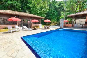 博西坎加派若拉达马塔酒店的一座大型蓝色游泳池,位于房子旁边