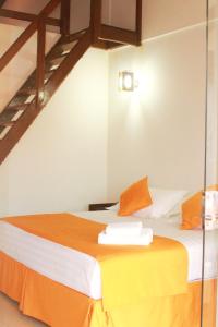 San Ignacio de VelascoHotel Tierra Linda的配有橙色和白色床单的床的客房