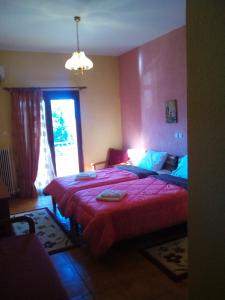 科尼察阿乌斯酒店的一间卧室配有一张带红色棉被的床和窗户。