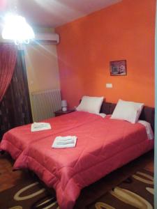 科尼察阿乌斯酒店的一间卧室配有红色的床和毛巾