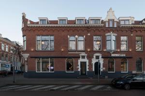 鹿特丹照明酒店的一座红砖建筑,前面有一辆汽车