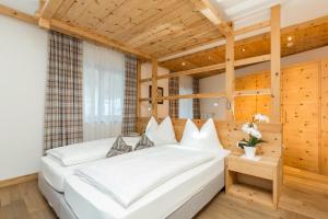 科瓦拉因巴迪亚贝斯特酒店的卧室配有一张白色大床,位于带木墙的房间内