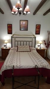 卡韦苏埃拉德尔瓦列Apartamentos Rurales Tauro的一间卧室配有一张大床、两张桌子和两盏灯。