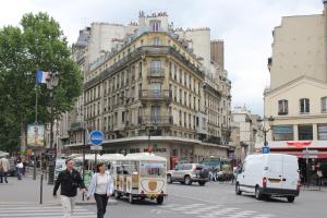 巴黎蓝色之家公寓的男人和女人用车辆穿过繁忙的城市街道
