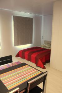 派尔努Vetesina的一间卧室配有一张带红色毯子和桌子的床。