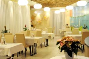 卢塞恩罗特塞福肯艾姆酒店的一间设有白色桌椅和鲜花的餐厅
