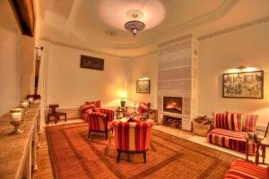 马拉喀什艺术田园庭院旅馆的客厅配有红色椅子和壁炉