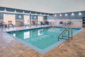 俾斯麦俾斯麦智选假日酒店的大楼内带桌椅的大型游泳池
