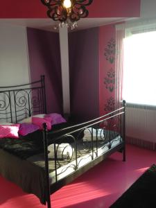 索波特SuperiQ Villa Sopot的一间卧室配有一张黑色床、紫色墙壁和吊灯。