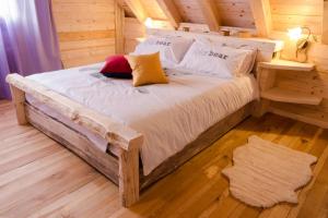 ComegliansDolomiti Village的木质客房的一张床位,铺有木地板