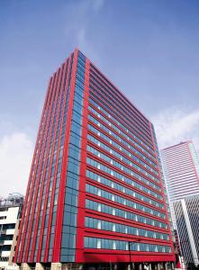 东京Hotel Villa Fontaine Grand Tokyo-Tamachi的城市里一座高大的红色办公楼